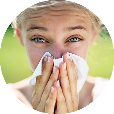 a woman blowing her nose during allergy season.